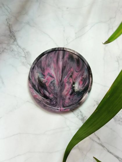 A beautiful blend of pink, black, and white in this recycled plastic coaster. The unique pattern makes it a standout piece for any modern home.