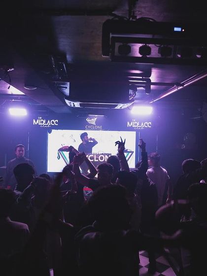 The crowd at Cyclone with their hands up, seen from a distance.