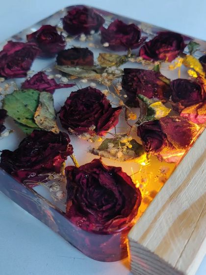 This resin block preserves a client's bouquet of roses, turning them into a permanent piece of art. The wooden base with an LED light makes the flowers glow beautifully.