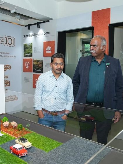 Visitors at the Farm Expo examining a model of a farm villa plot.