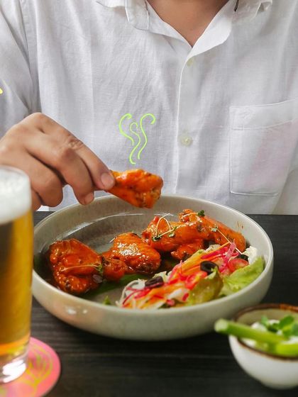 A perfect pairing of spicy buffalo chicken wings and a cold glass of beer.