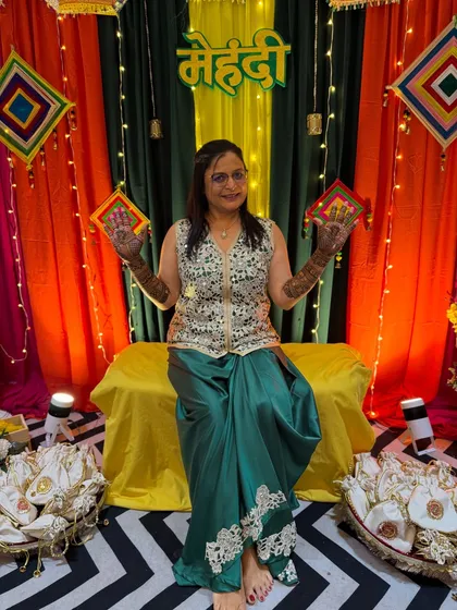 A full-length view of the groom's mom, happy and ready for the festivities with her beautiful mehendi.