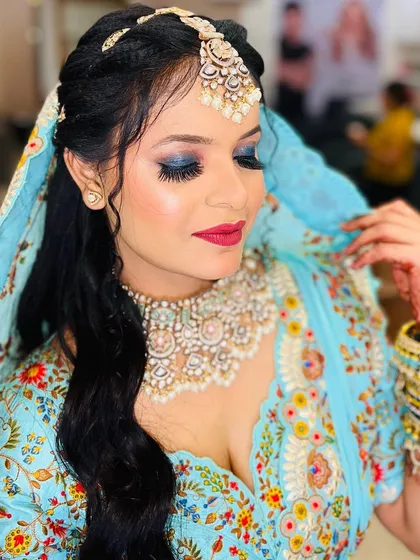 A close-up of the client in the light blue floral saree, focusing on her bold blue smokey eye makeup. This look is perfect for someone who wants their eyes to be the center of attention.