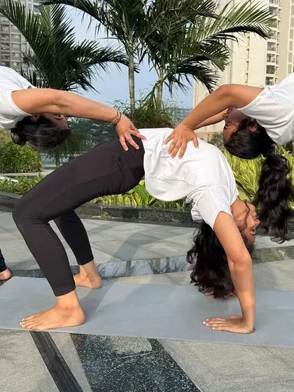 Another angle of this beautiful three-person backbend. It highlights the alignment, strength, and trust required to create such a supportive and interconnected shape.