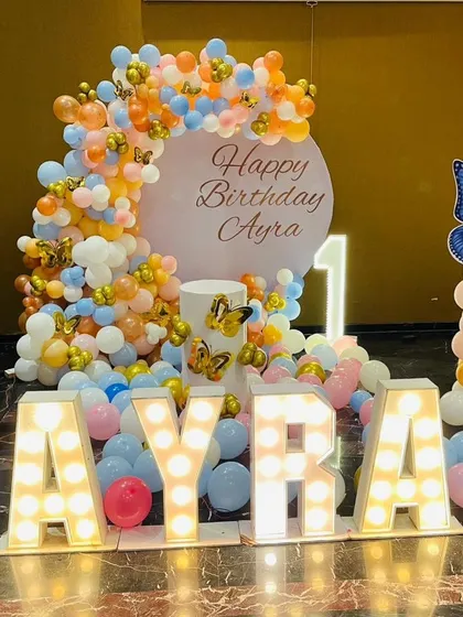 A stunning butterfly-themed first birthday for Ayra. We used large light-up letters for the name as a centerpiece, surrounded by a colorful pastel balloon arrangement and butterfly accents.