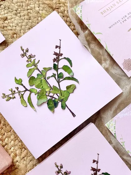 A close-up of the hand-appliquéd Tulsi cutout. This three-dimensional element adds a unique, tactile quality to the invitation, making it stand out.