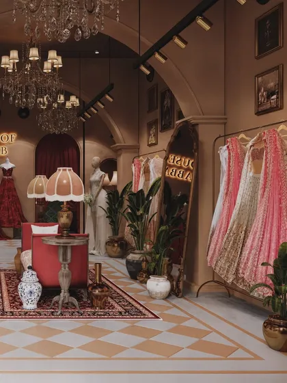 A view inside the House of Sabbab boutique, showing the lounge area with a red sofa and ornate rug, creating a luxurious client experience.