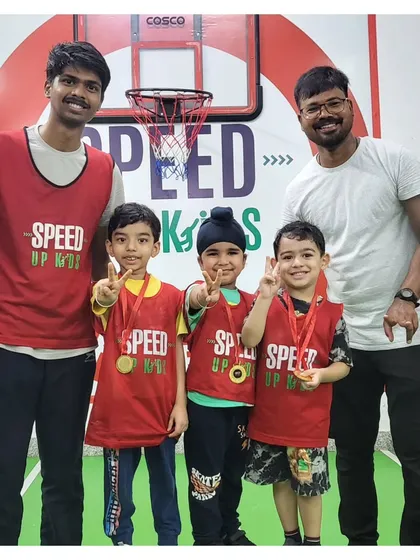 Coaches and kids celebrating with medals and peace signs. These moments of recognition are what build lasting confidence.
