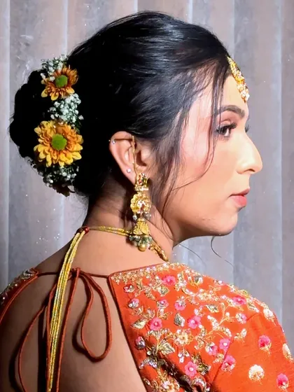 A side profile showing the elegant floral bun and the details of her jewelry.