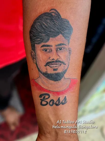A portrait tattoo with the word "Boss" underneath. A great way to pay respect to a mentor, father, or friend.