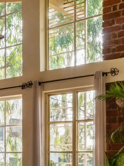 Another view of the expansive, double-height windows that bring the outdoors in. This design ensures the interior is always bright and connected to the lush, natural surroundings.