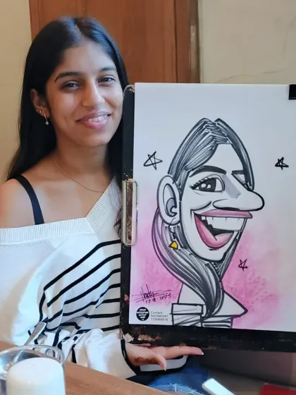 Another angle of this happy customer with her finished caricature. The pink background adds a nice pop of color.