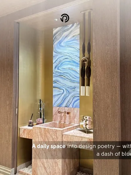 A powder room is the perfect place for a bit of design poetry. I used a stunning blue-and-white art panel as a backsplash, paired with a pink marble sink and unique pendant lights to turn this daily space into a work of art.