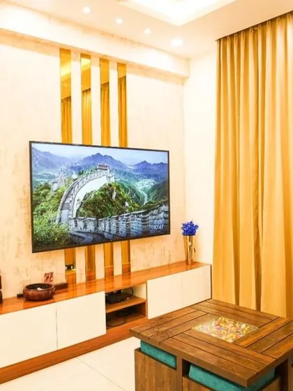 Modern luxury is all about the details. This living room showcases our ability to blend bold design choices, like the geometric gold-mirrored partition and feature wall, with comfortable, elegant furnishings for a truly glamorous result.
