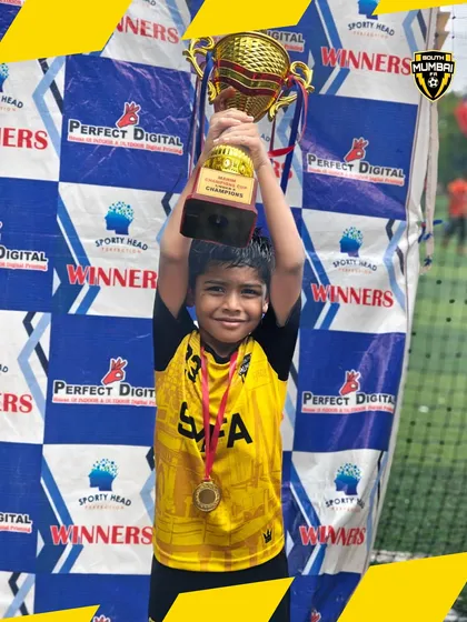 Lifting the trophy high. This U8 player embodies the spirit of victory that we cultivate at SMFA.