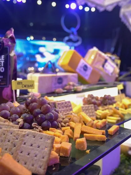 A lavish cheese board featuring Red Cheddar, crackers, grapes, and nuts. This is part of our international cheese bar, a sophisticated offering for any event.