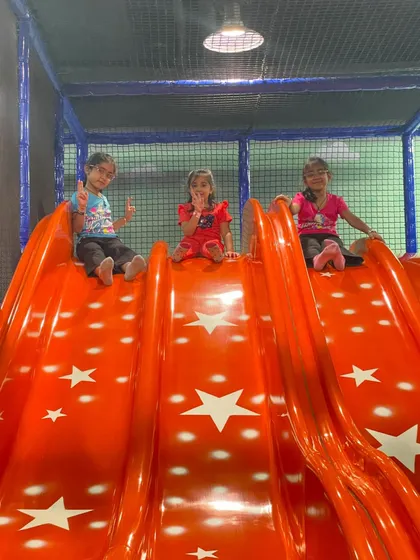 A happy trio ready to go down the big slide. It's always more fun with friends!