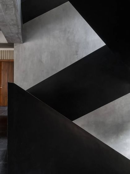 The play of light on the intersecting planes of the Brick House staircase creates a composition of abstract shapes and textures.