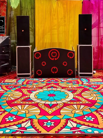 For a lively Haldi or Mehndi, the music is just as important as the decor. I arrange for the complete DJ and sound system setup, ensuring it integrates perfectly with the vibrant decor, like this colorful mandala-print dance floor.