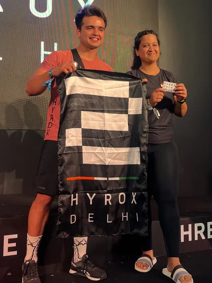 Celebrating a successful finish with one of my athletes at Hyrox Delhi. Holding that finisher flag is a feeling of pure accomplishment.