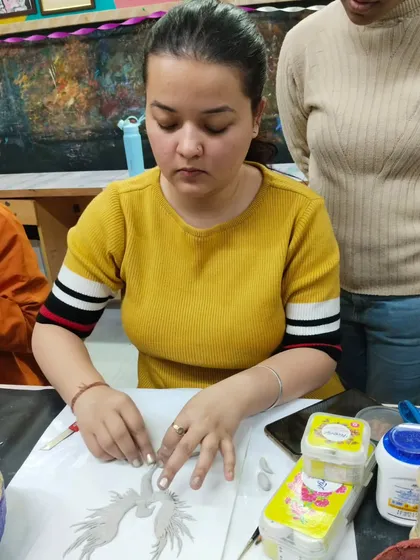 A student shaping and applying small pieces of clay to build up her 3D design in our Shilpkar art workshop.