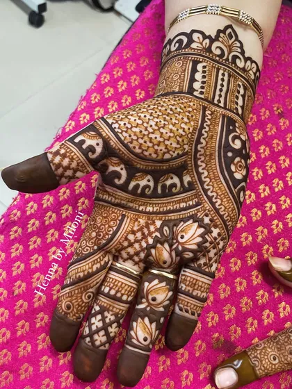 A single-hand view of this festive Karva Chauth design. The tiny elephants marching around the wrist add a playful and traditional touch.