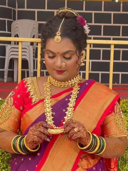 A close-up of the bride's glowing makeup. The look features soft, shimmery eyes and a bold lip, perfectly complementing her gold jewelry and traditional attire.
