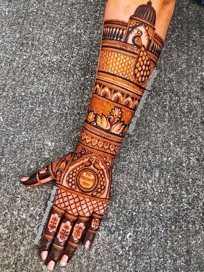 A single-arm design featuring a mix of traditional motifs like peacocks, swans, and a personalized name.