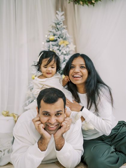 A family playing peek-a-boo under a blanket. The holidays are all about fun, laughter, and being together.