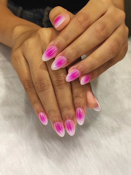 This is the popular aura nail trend. This set features a vibrant pink aura gradient on a white base, creating a soft, glowing effect on almond-shaped nails.