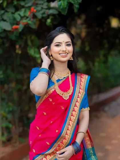 A fairytale moment in a garden setting. This bride looks absolutely radiant in her pink and blue Paithani saree, with soft, natural makeup enhancing her smile.