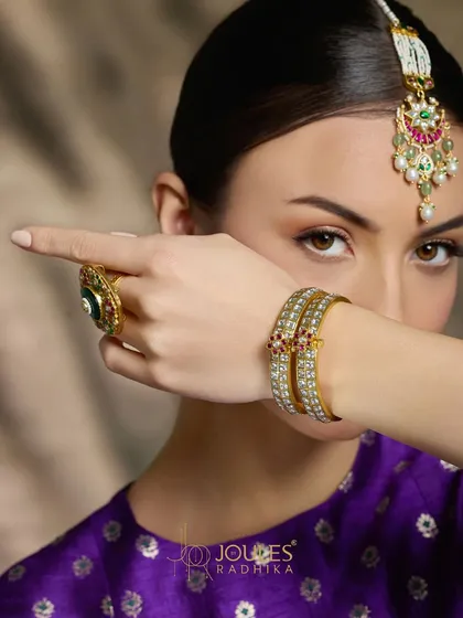 From head to hand, let Aalayaa weave its magic. A model showcasing a maang tikka, delicate bangles, and a statement ring from the collection.