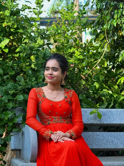 My enchanting client Nisarga looks stunning in this vibrant orange gown. I designed it with a flowing pleated skirt and an intricately embroidered bodice, creating a look of timeless elegance for her special event.