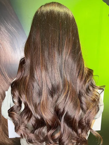 The stunning "after" result. A deep base melts into beautiful wine red ends, styled with voluminous waves.
