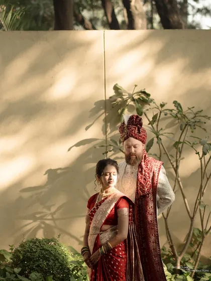 A fine art portrait capturing the couple in a moment of quiet reflection. The play of light and shadow adds a dramatic, painterly quality to this cross-cultural wedding shot.