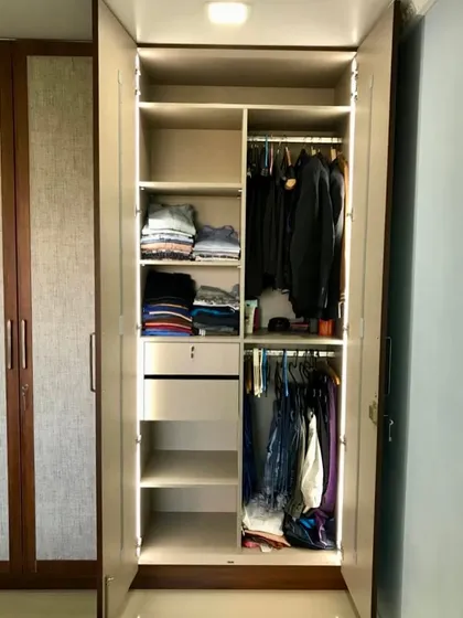 This section of the wardrobe is designed for folded clothes and includes a lockable drawer for valuables, combining practicality with elegant design.