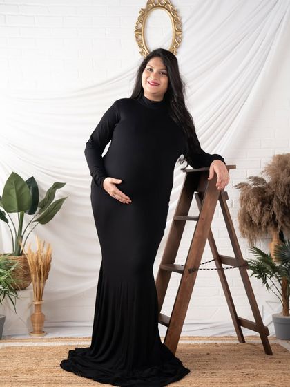 A simple and elegant solo portrait in a classic black gown. The clean lines and rustic props create a timeless and sophisticated look.
