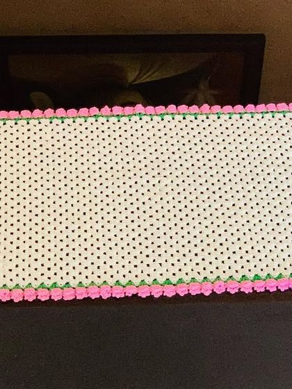 A top-down view of the cream and pink tulip-edged table runner.