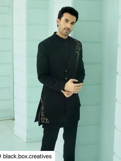 A modern and stylish look for an editorial shoot. The grooming is minimal and masculine, focusing on flawless skin and perfectly styled hair to complement the Indo-western outfit.