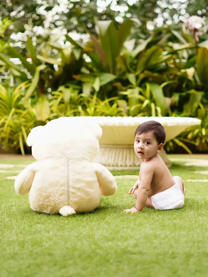 The baby turns to look at the camera, a moment of connection during his outdoor playtime. Natural light and settings create beautiful, authentic portraits.
