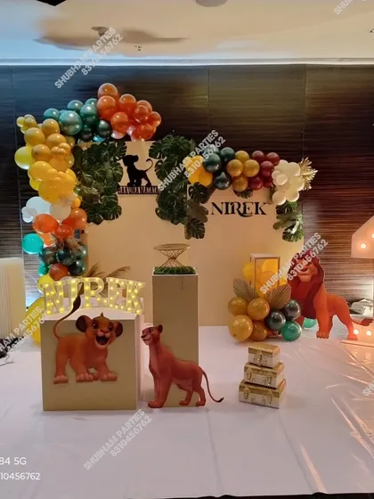 A "Hakuna Matata" Lion King theme for a first birthday party. This jungle-inspired decoration includes character cutouts of Simba and Nala, marquee letters and numbers, and a balloon arrangement in earthy tones to bring the safari to your event.
