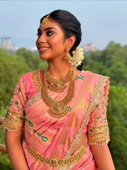A beautiful candid moment. The soft, natural light highlights the seamless finish of her makeup and the intricate details of her bridal attire.