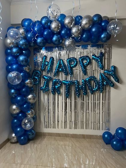 A classic blue and silver balloon arch with a shimmer curtain. This simple setup is perfect for adding a festive touch to any home party.