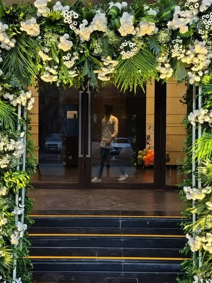 A lush and elegant floral archway, demonstrating that our decor skills extend beyond balloons. This beautiful entrance, made of white flowers and rich greenery, is perfect for a sophisticated wedding or upscale event.