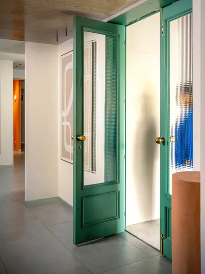 We love using color to make an impact. These tall, reeded glass doors painted in a deep teal create a dramatic entrance to a private consultation room, contrasting beautifully with the neutral interior.