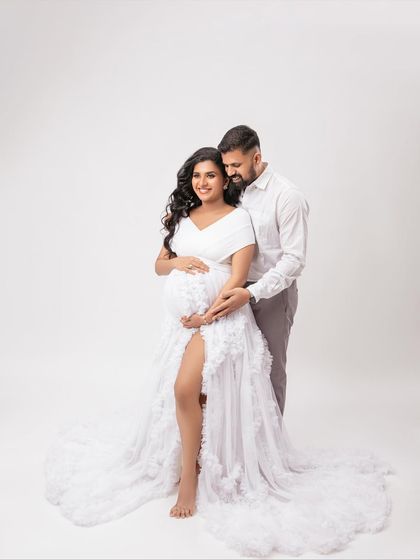 A classic couple's pose, standing together and radiating happiness. The white ruffled gown adds a touch of romance and elegance.