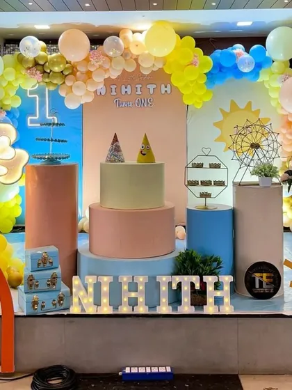 A bright and sunny first birthday party with a modern pastel theme. I used unique props like sun and rainbow cutouts, a miniature ferris wheel, and a multi-colored balloon arch to create a joyful vibe.