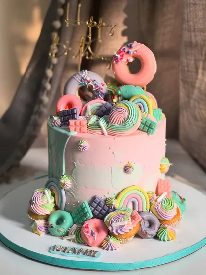 Welcome to a sweet Candyland dream. This cake was designed to be a party in itself, overflowing with colorful donuts, rainbows, and mini cupcakes. It’s a perfect centerpiece for a child's birthday, designed to spark pure joy.
