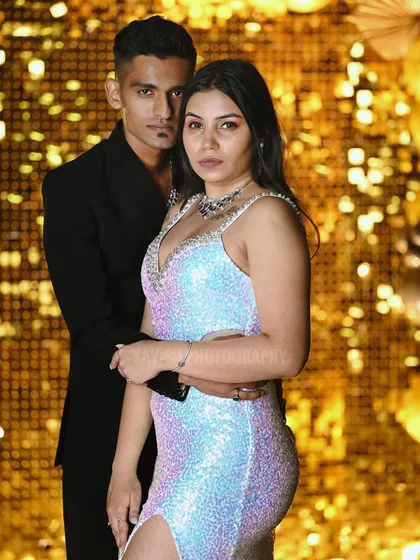 A close-up of the couple against the gold backdrop, creating a high-impact, celebratory portrait.
