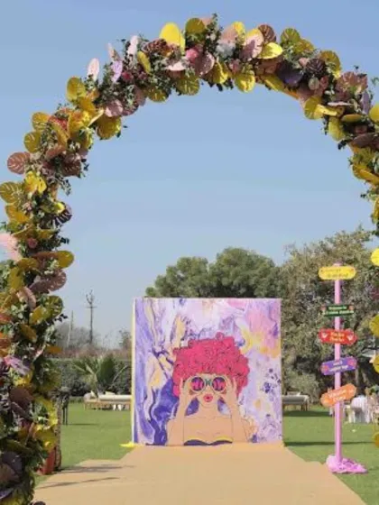 A quirky and colorful entrance for a Haldi ceremony, featuring a playful art installation and a unique floral arch.